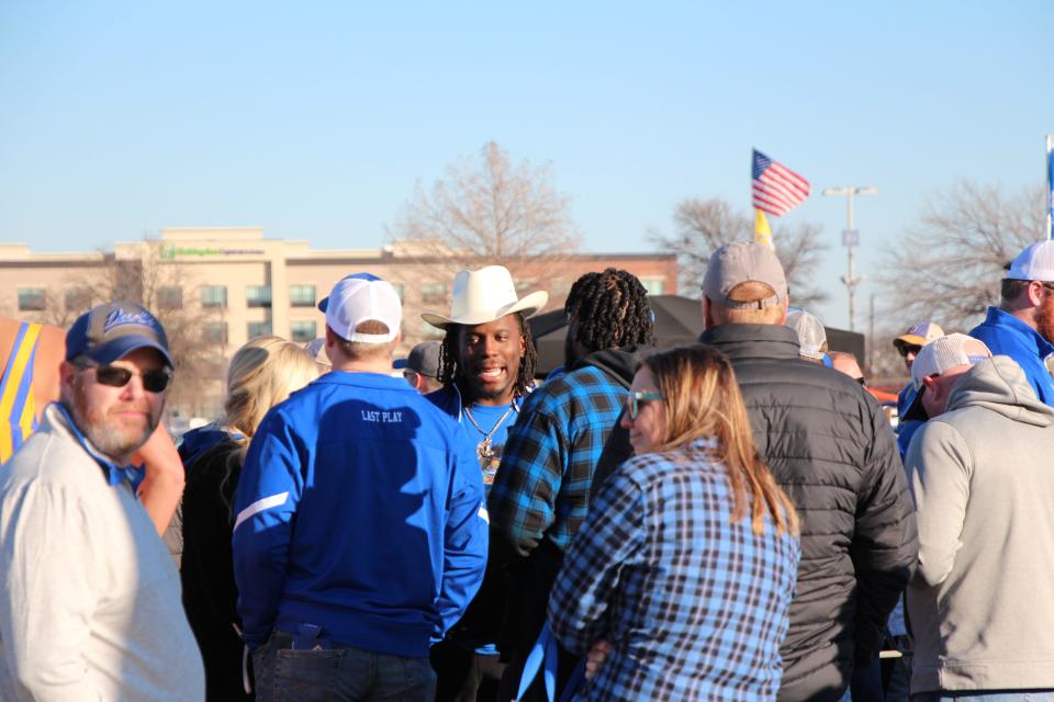 Former SDSU defensive end Tolu Ogunrinde (in cowboy hat) talks with fans during the pregame tailgate on Sunday.