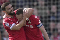 Wrexham's Paul Mullin, right, celebrates with Elliot Lee after scoring their side's fourth goal of the game during the Sky Bet League Two match at the SToK Cae Ras, Wrexham, England, Saturday April 13, 2024. (Jacob King/PA via AP)