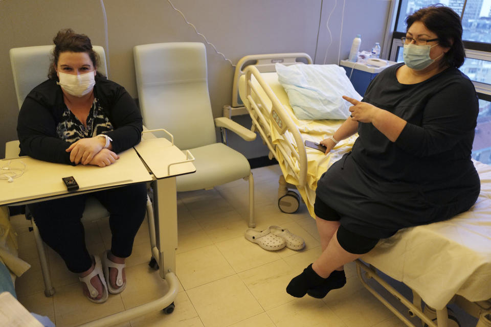 Lolita Andela, left, who works as a carer for a disabled man and Caroline Erganian, a retired secretary, chat in their room on the eve of their surgery at Bichat Hospital, AP-HP, in Paris Tuesday, Dec. 1, 2020. Hospitals are increasingly grappling with giant backlogs of surgeries that were postponed when COVID-19 hit. To prevent the collapse of their public health systems, countries hard-hit by the virus in Europe prioritized virus patients and put off nonessential procedures, and even some essential ones. (AP Photo/Francois Mori)