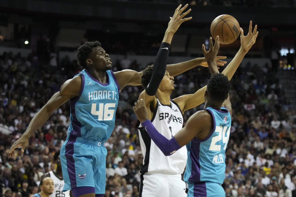 Charlotte Hornets' James Nnaji, left, and San Antonio Spurs' Victor Wembanyama battle for a rebound beside Charlotte Hornets' Brandon Miller, right, during the first half of an NBA summer league basketball game Friday, July 7, 2023, in Las Vegas. (AP Photo/John Locher)