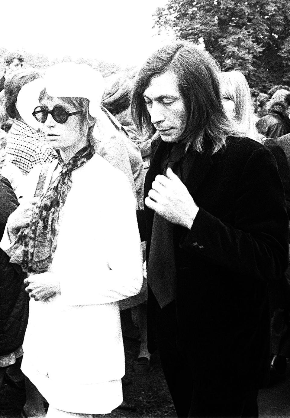 Sad-faced Charlie Watts of the Rolling Stones and his wife Shirley Watts stand at the graveside of Brian Jones. former guitarist with the group, whose funeral took place in Cheltenham., Gloucestershire.   (Photo by PA Images via Getty Images)