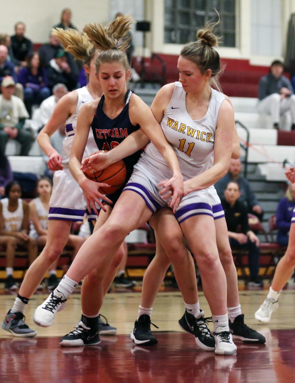 Warwick's Lindsay Evans and Ketcham's Caitlin Robertson wrestle for possession of the ball during a Class AA girls basketball regional semifinal on March 8, 2022.