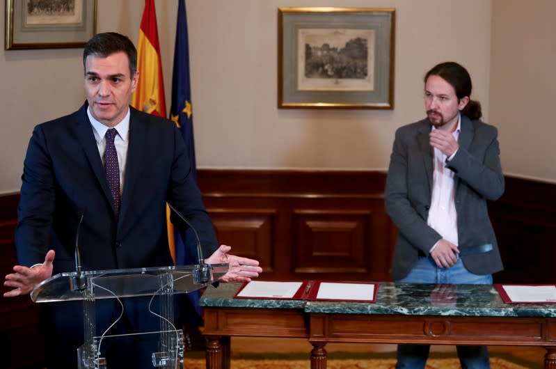 El presidente del gobierno en funciones de España, Pedro Sánchez, y el líder de Unidas Podemos, Pablo Iglesias, firman un acuerdo de coalición durante una conferencia de prensa en el Congreso de los Diputados en Madrid