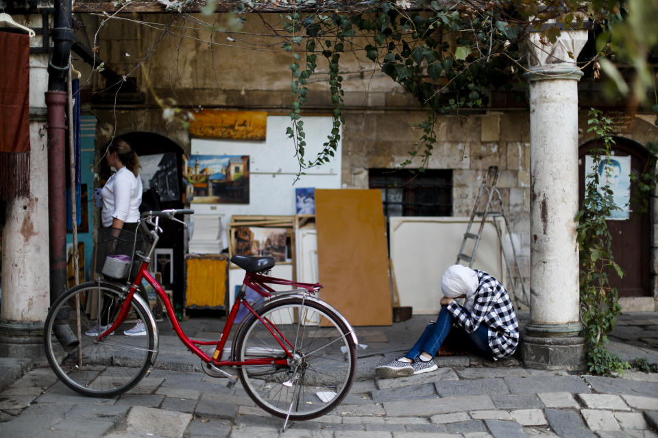 A Syrian student sits on the ground while studying in the Takiyya complex, an ancient construction with landscaped courtyards built on the banks of the Barada River in Damascus, Syria, Wednesday, Oct. 3, 2018. President Bashar Assad told a little-known Kuwaiti newspaper on Wednesday that Syria has reached a "major understanding" with Arab states after years of hostility over the country's civil war. (AP Photo/Hassan Ammar)