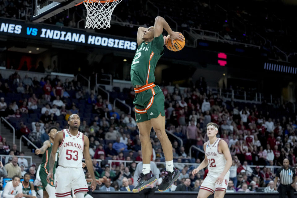 Miami's Isaiah Wong (2) dunks as Indiana's Tamar Bates (53) and Miller Kopp (12) look on in the second half of a second-round college basketball game in the NCAA Tournament, Sunday, March 19, 2023, in Albany, N.Y. (AP Photo/John Minchillo)