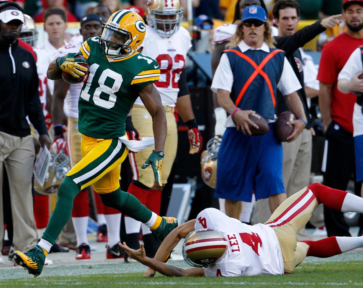 Green Bay Packers returner Randall Cobb evades a tackle by San Francisco 49ers punter Andy Lee en route to a 75-yard punt return for a touchdown.