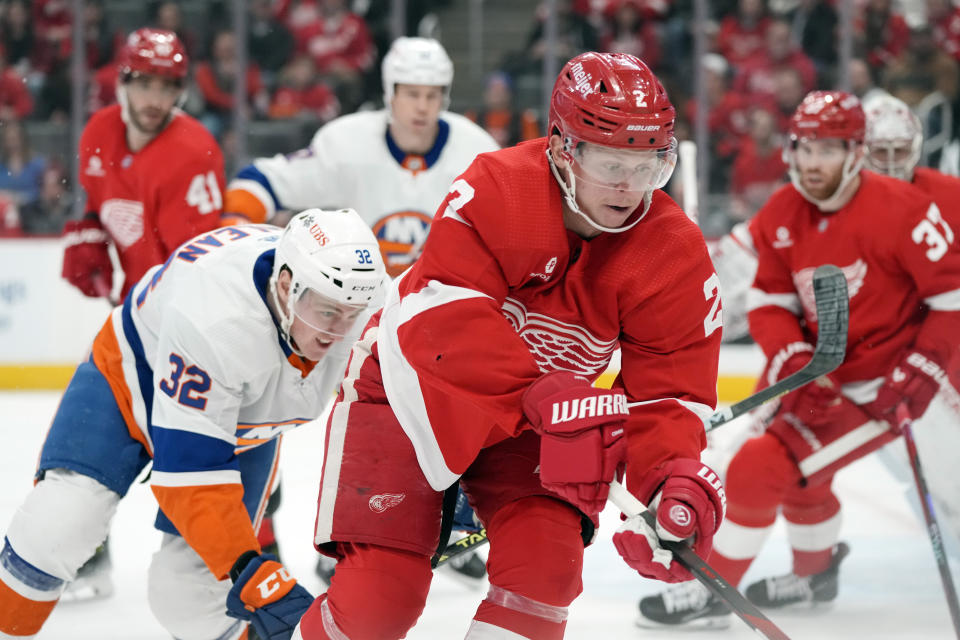 Detroit Red Wings defenseman Olli Maatta (2) and New York Islanders center Kyle MacLean (32) chase the puck during the first period of an NHL hockey game, Thursday, Feb. 29, 2024, in Detroit. (AP Photo/Carlos Osorio)