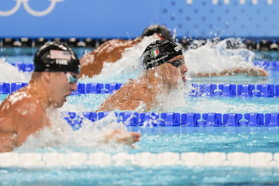 Nicolo Martinenghi, center, of Italy, competes in the men's 100-meter breaststroke test at the 2024 Summer Olympics, Sunday, July 28, 2024, in Nanterre, France. (AP Photo/Martin Meissner)