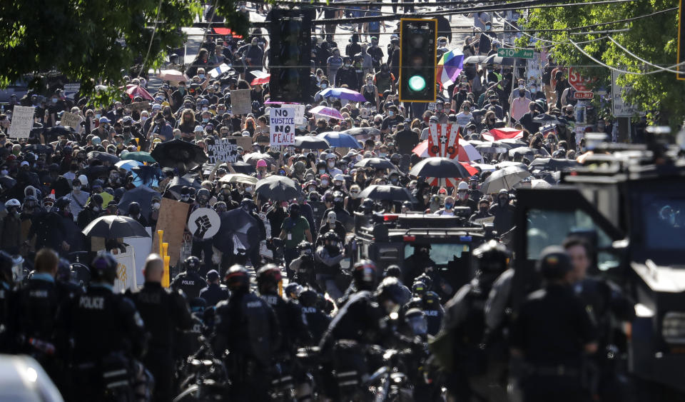 Police clash with protesters Saturday, July 25, 2020, during a Black Lives Matter protest near the Seattle Police East Precinct headquarters in Seattle. A large group of protesters were marching Saturday in Seattle in support of Black Lives Matter and against police brutality and racial injustice. (AP Photo/Ted S. Warren)