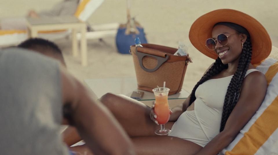 Molly drinking a cocktail on the beach