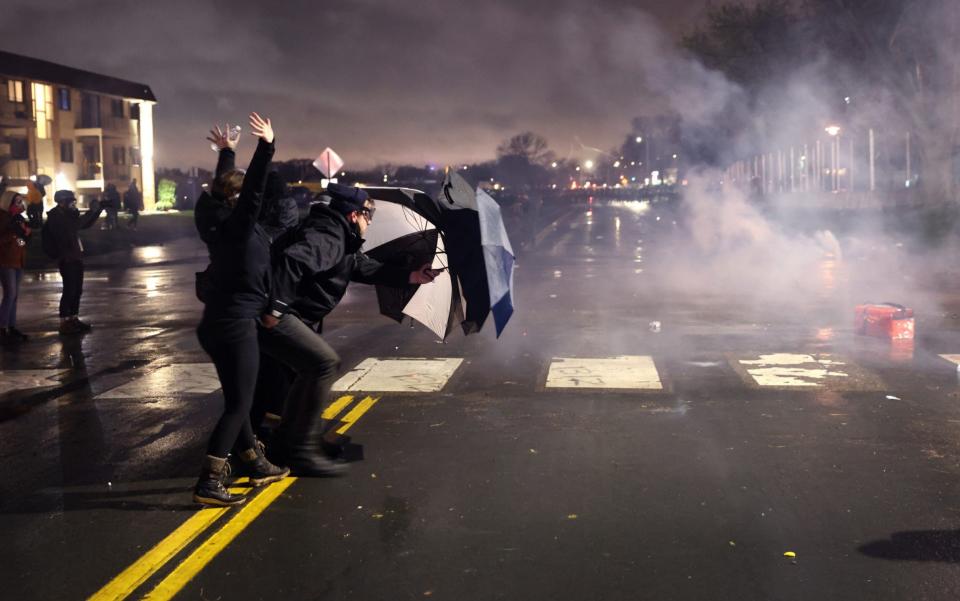 Demonstrators face off with police officers outside of the Brooklyn Center police station