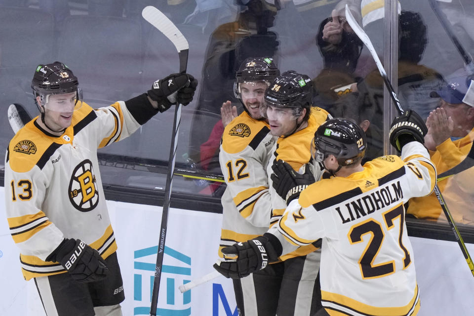 Boston Bruins left wing Jake DeBrusk (74), second from right, celebrates with center Charlie Coyle (13), defenseman Kevin Shattenkirk (12) and Hampus Lindholm (27) after scoring in the second period of an NHL hockey game against the Toronto Maple Leafs, Thursday, Nov. 2, 2023, in Boston. (AP Photo/Steven Senne)