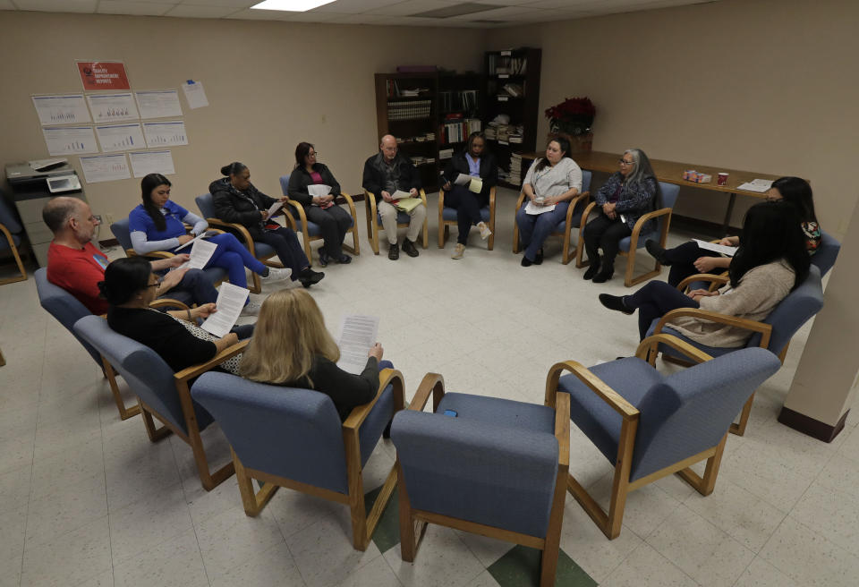 Annette Squetimkin-Anquoe, third from right, a member of the Colville Indian tribe and the Chief Traditional Health Officer at the Urban Indian Health Institute in Seattle, leads a talking circle meeting Friday, Jan. 11, 2019, to discuss the practice of traditional Indian medicine, including blessings and smudging, with employees of the Seattle Indian Health Board. Fallout from the federal government shutdown is hurting hundreds of Native American tribes and entities that serve them. The pain is especially deep in tribal communities with high rates of poverty and unemployment, and where one person often supports an extended family. (AP Photo/Ted S. Warren)