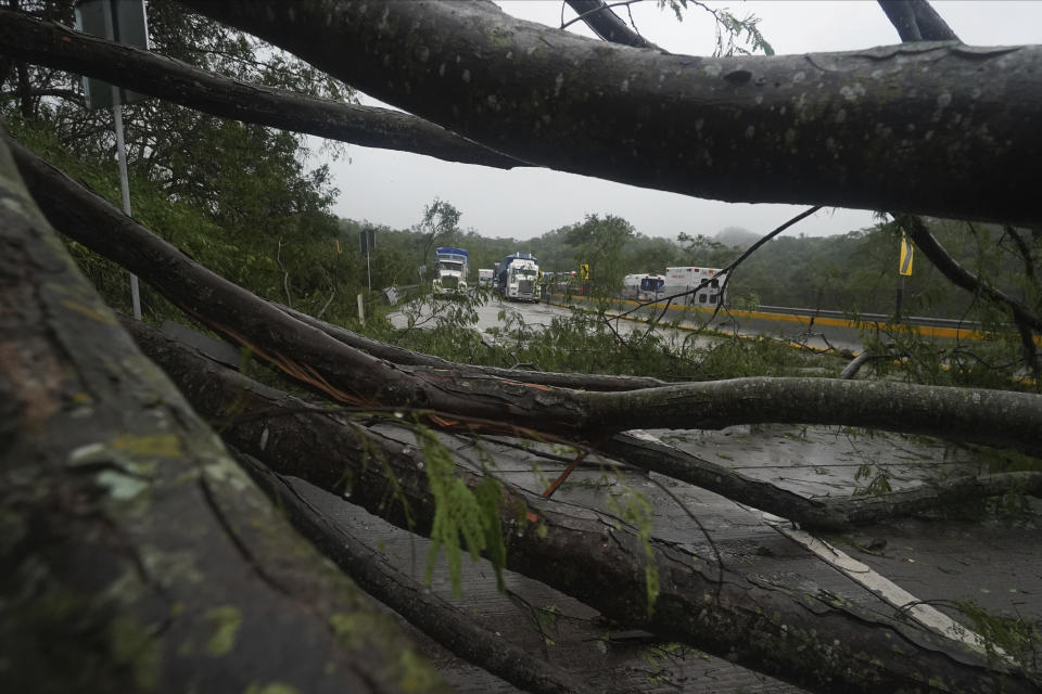 Trucks sit idle on a highway blocked by a landslide triggered by Hurricane Otis near Acapulco, Mexico, Wednesday, Oct. 25, 2023. (AP Photo/Marco Ugarte)