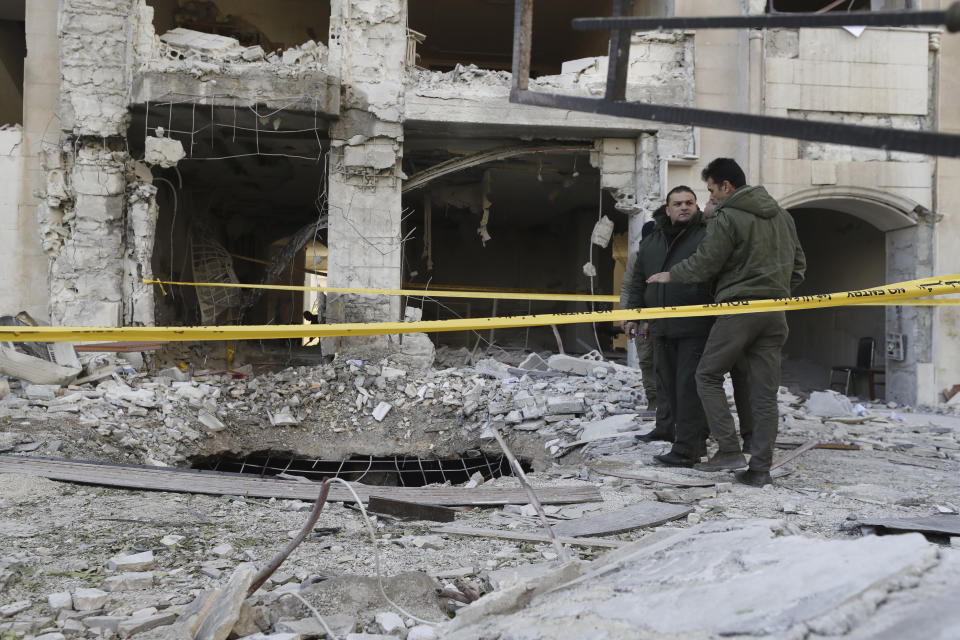 Syrian security officers inspect the damage in a residential neighborhood after an early morning Israeli airstrike in the capital city of Damascus, Syria, Sunday, Feb. 19, 2023. Syrian state news reported that Israeli airstrikes have targeted a residential neighborhood in central Damascus. (AP Photo/Omar Sanadiki)