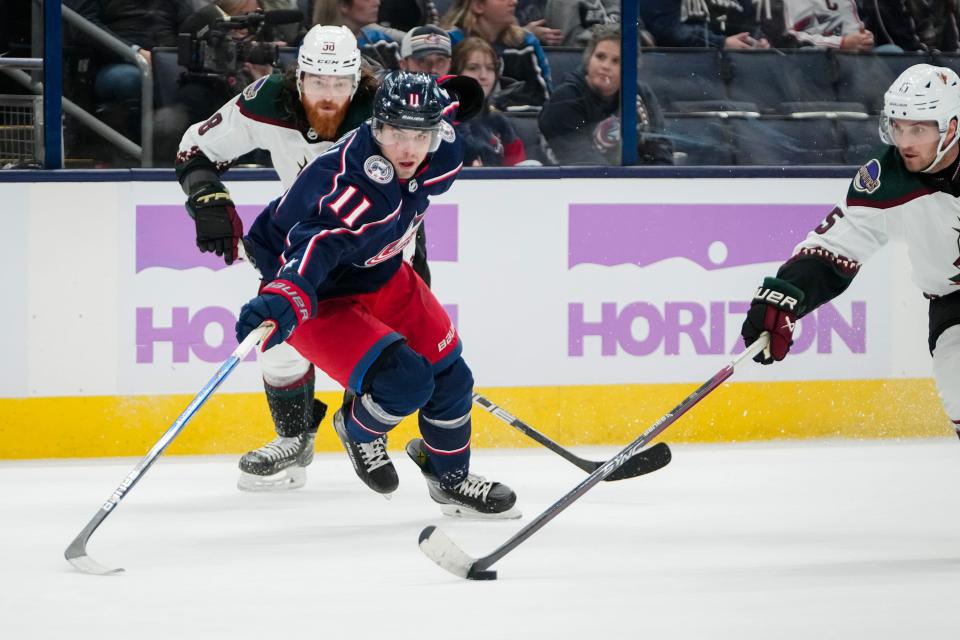 Nov 16, 2023; Columbus, Ohio, USA; Columbus Blue Jackets center Adam Fantilli (11) reaches for a puck controlled by Arizona Coyotes center Alexander Kerfoot (15) during the second period of the NHL hockey game at Nationwide Arena.