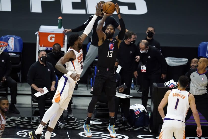 Clippers guard Paul George takes a shot over Phoenix Suns center Deandre Ayton on April 8 at Staples Center.