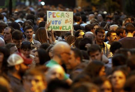 A supporter of Ahora Madrid (Now Madrid) raises up a placard as they gather at party's meeting area after the regional and municipal elections in Madrid, Spain, May 24, 2015. REUTERS/Paul Hanna