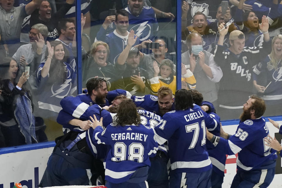 Tampa Bay Lightning teammates surround goaltender Andrei Vasilevskiy after the Lighting defeated the Montreal Canadiens 1-0 to win the Stanley Cup in Game 5 of the NHL hockey finals, Wednesday, July 7, 2021, in Tampa, Fla. (AP Photo/Gerry Broome)