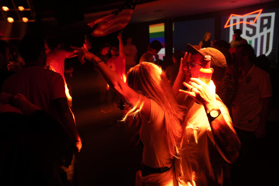 People dance during an official U.S. Soccer fan party at the Budweiser World Club ahead of a FIFA World Cup group B soccer match between the United States and Wales, in Doha, Sunday, Nov. 20, 2022. (AP Photo/Ashley Landis)