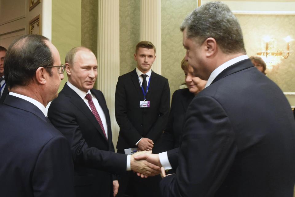 FILE - Russian President Vladimir Putin, second left, and Ukrainian President Petro Poroshenko, right, shake hands as French President Francois Hollande, left, and German Chancellor Angela Merkel look on during a meeting in Minsk, Belarus, Feb. 11, 2015. A peace agreement for eastern Ukraine has remained stalled for years, but it has come into the spotlight again amid a Russian military buildup near Ukraine that has fueled invasion fears. On Thursday, Feb. 10, 2022 presidential advisers from Russia, Ukraine, France and Germany are set to meet in Berlin to discuss ways of implementing the deal that was signed in the Belarusian capital of Minsk in 2015. (Andrei Stasevich/BeITA via AP, file)
