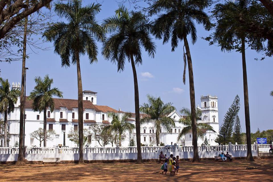 Palm trees fringe the famous Se Cathedral built in a Portuguese-Gothic style in Velha Goa, Goa, India