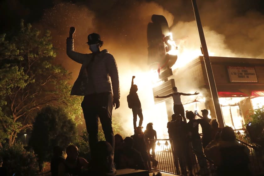 Protesters near a burning fast food restaurant in Minneapolis early Friday.