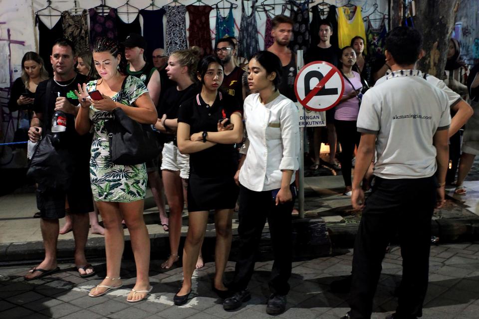 <p>Foreign tourists and hotel staff stand on the street afer being evacuated in Bali’s capital Denpasar on Aug. 5, 2018, after a major earthquake rocked neighbouring Lombok island. (Photo: Hendra Broetal/AFP/Getty Images) </p>