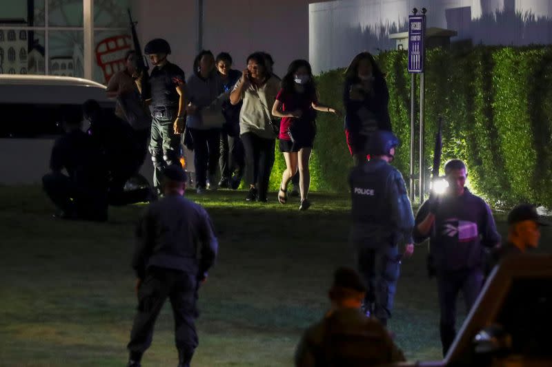 Thailand security forces evacuate people from a shopping mall as they chase a shooter hidden inside after a mass shooting in front of the Terminal 21, in Nakhon Ratchasima