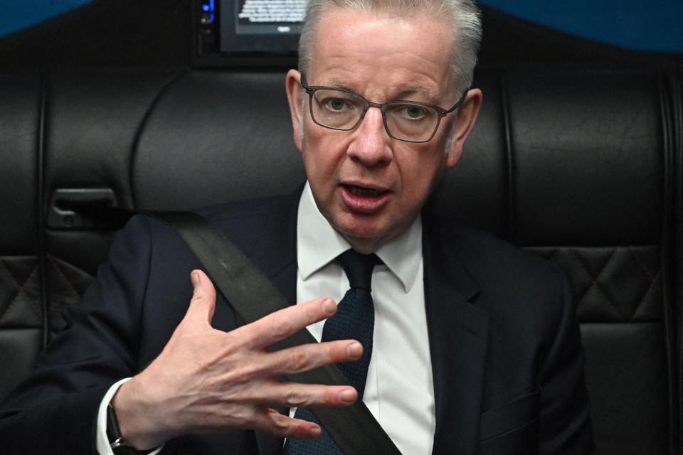 Britain's Levelling Up, Communities and Housing Secretary Michael Gove speaks to members of his team while travelling on the Conservative campaign bus in London (POOL/AFP via Getty Images)