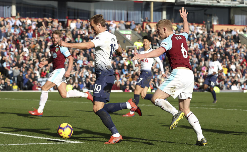 Tottenham Hotspur's Harry Kane, left, runs in to score his side's first goal of the game against Burnley during their English Premier League soccer match at Turf Moor in Burnley, England, Saturday Feb. 23, 2019. (Martin Rickett/PA via AP)
