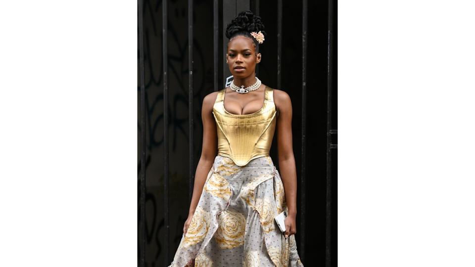 Didi Stone is seen wearing a gold Vivienne Westwood top and skirt and gold strapped heels outside the Vivienne Westwood show during Paris Fashion Week S/S 2022 on October 02, 2021 in Paris,