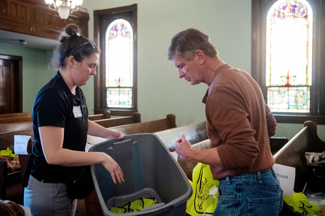 Rachel Taylor, a City of Asheville Economic Development Specialist, and Brian Methvin prepare vests for volunteers before the annual point in time count, which records demographics and the number of people experiencing homelessness in Asheville.
