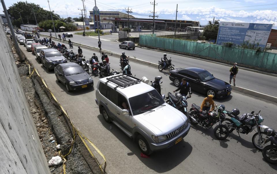 Drivers and motorcyclists wait their turn to fill up at a gas station in Cali, Colombia, Friday, May 7, 2021. Protesters are blocking the main roads as a part of anti-government protests that has resulted in cities having a shortage of food and fuel. (AP Photo/Andres Gonzalez)