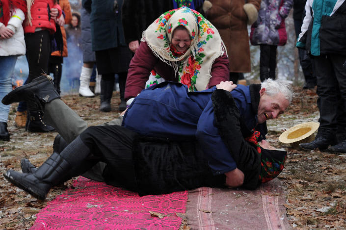 <p>Villagers roll on the ground as they take part in a Chyrachka rite during the Maslenitsa celebration in the village of Tonezh, Belarus, Feb. 26, 2017. Maslenitsa is an ancient farewell ceremony to winter, traditional in Belarus, Russia and Ukraine. (Photo: Sergei Gapon/AFP/Getty Images) </p>