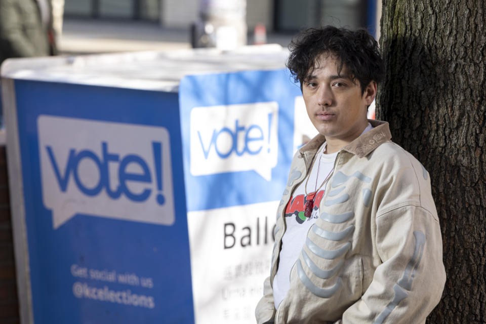 Kenji Takada-Dill, de 30 años, posa para una foto junto a un buzón en el que los votantes pueden dejar sus papeletas en el estado de Washington, en el que existe un programa de votación por correo, el miércoles 13 de marzo de 2024, en Seattle. (AP Foto/Jason Redmond)