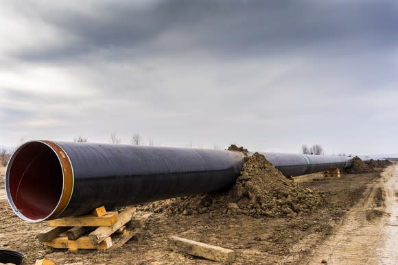 A gas pipeline under construction with a cloudy sky in the background.