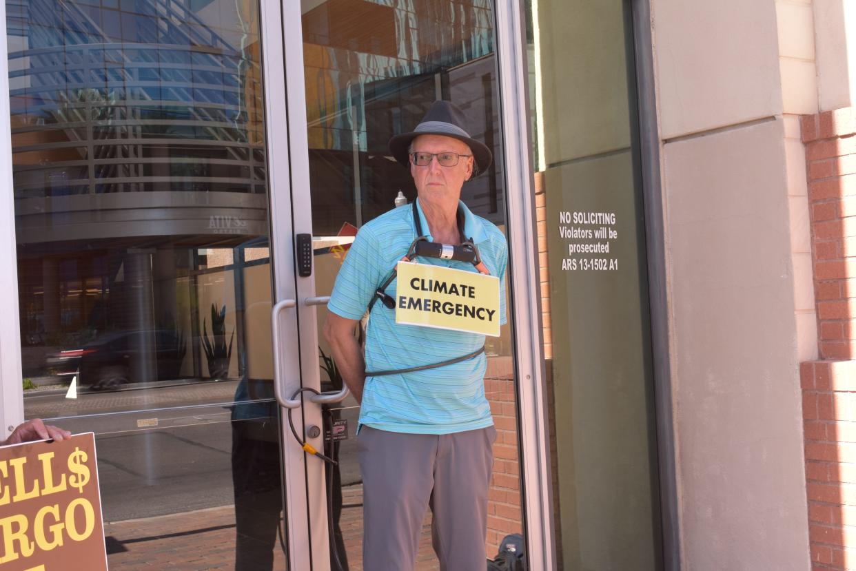 Troy Horton ties himself to the front doors of a building in Tempe that houses a Wells Fargo branch to protest the bank's financing of fossil fuels emissions.