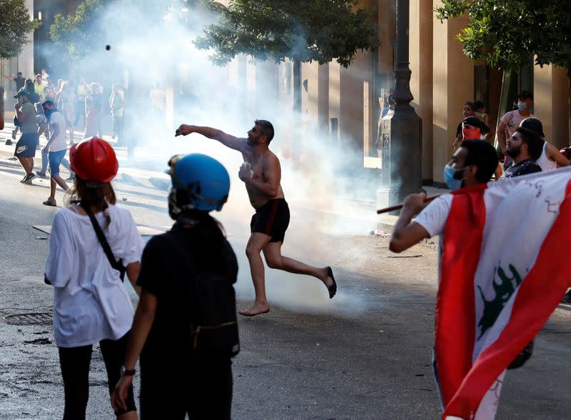 A demonstrator throws a stone during a protest in Beirut