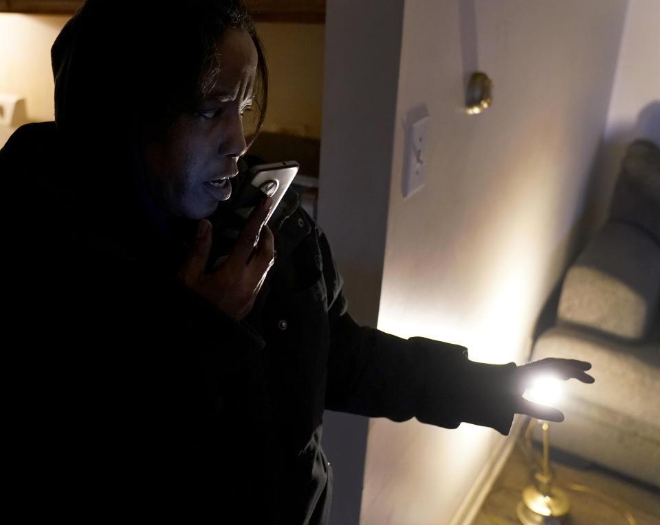 Genevieve Tyler talks with a community activist on the phone trying to find a heater for the apartment she is living in Monday, Jan. 8, 2024, in Harvey, Ill. Tyler, who was recently laid off from her meat factory job, heard noises outside and ran for a second door in her apartment thinking it was a break-in. She then came upon crews boarding up her windows. "I feel sick," she said, adding that she was too scared to return home. "I'm still sad."(AP Photo/Charles Rex Arbogast)