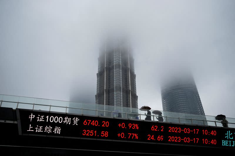 FILE PHOTO: An electronic board shows stock indices at the Lujiazui financial district in Shanghai