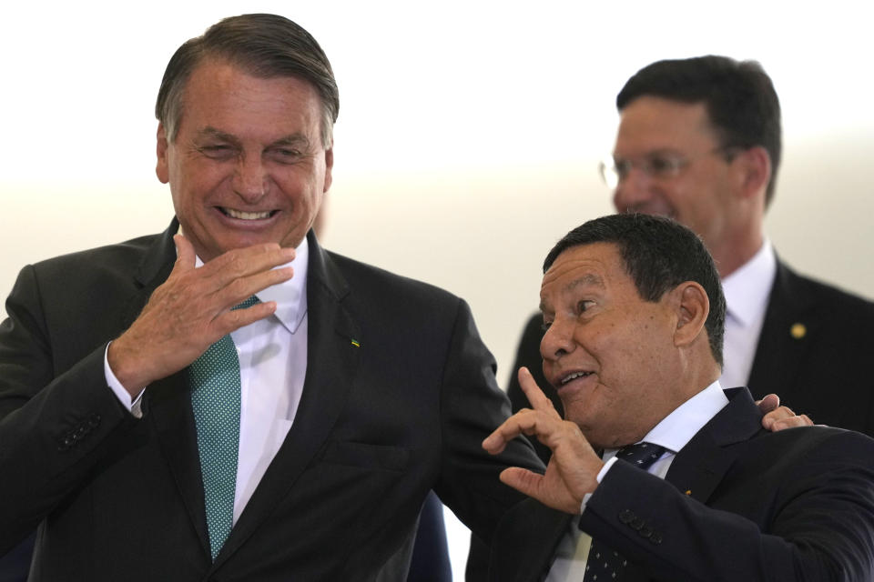 Brazilian President Jair Bolsonaro, left, speaks with his Vice President Hamilton Mourao before the start of the launch ceremony for a housing program at Planalto presidential palace in Brasilia, Brazil, Wednesday, Sept. 15, 2021. (AP Photo/Eraldo Peres)