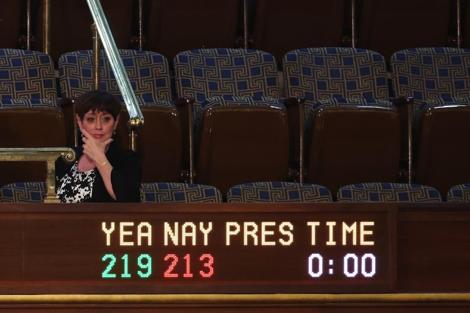 Kevin McCarthy's wife sits by a sign in the House chamber indicating vote numbers