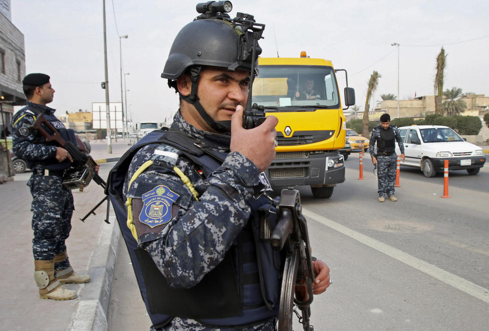 Iraqi federal policemen stand guard at a checkpoint in Basra, Iraq's second-largest city, 340 miles (550 kilometers) southeast of Baghdad, Iraq, Thursday, Jan. 2, 2014. The Iraqi government has tightened its security measures after security forces have arrested, Wathiq al-Batat, a controversial Shiite cleric who leads an Iranian-backed militia called Mukhtar Army. (AP Photo/Nabil al-Jurani)