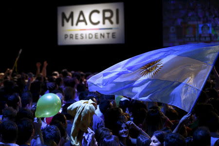A supporter of Argentinian presidential candidate Mauricio Macri waves an Argentinian national flag as they gather at their headquarters in Buenos Aires, November 22, 2015. REUTERS/Ivan Alvarado