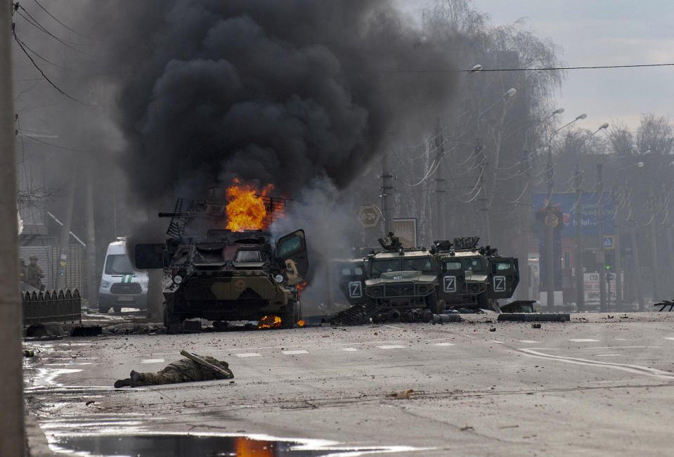 An armored personnel carrier burns and damaged light utility vehicles stand abandoned after fighting in Kharkiv, Ukraine, Sunday, Feb. 27, 2022. The city authorities said that Ukrainian forces engaged in fighting with Russian troops that entered the country's second-largest city on Sunday. (AP Photo/Marienko Andrew)