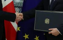 Britain's Ambassador to the European Union Tim Barrow delivers the instruments of ratification for Brexit, to European Council Secretary General Jeppe Tranholm-Mikkelsen in Brussels