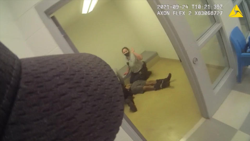 In this image from body camera video provided by Sedgwick County, staff members perform CPR on Cedric “C.J.” Lofton, 17, in Wichita, Kan., on Sept. 24, 2021. The final autopsy, released in December, listed C.J.'s cause of death as “complications of cardiopulmonary arrest sustained after physical struggle while restrained in the prone position.” The death was declared a homicide. (Sedgwick County via AP)