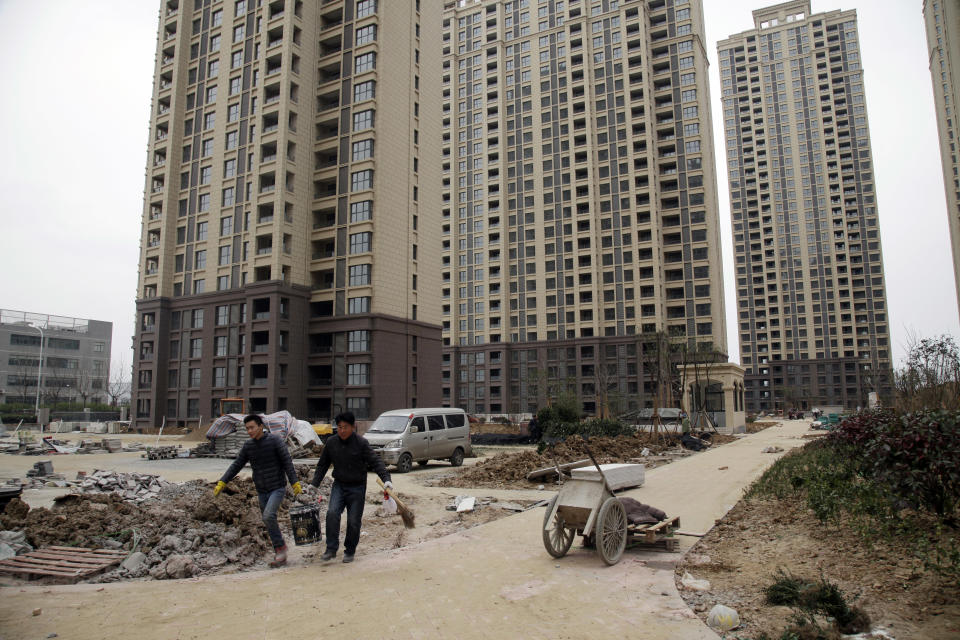 In this photo taken Friday, March 17, 2017, workers labor at a newly built condominium complex where a controversial mosque is planned in Hefei in central China's Anhui province. On the dusty plains of the Chinese heartland, the bitter fight over the mosque illustrates how a surge in anti-Muslim sentiment online is spilling over into the real world. If left unchecked, scholars say, such attitudes risk inflaming simmering ethnic tensions that have in past erupted in bloodshed. (AP Photo/Gerry Shih)