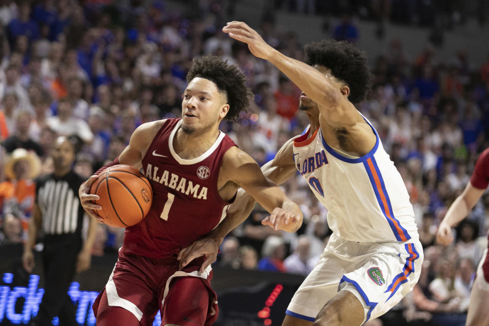 Alabama guard Mark Sears (1) drives drives against Florida guard Zyon Pullin (0) during the second half of an NCAA college basketball game Tuesday, March 5, 2024, in Gainesville, Fla. (AP Photo/Alan Youngblood)